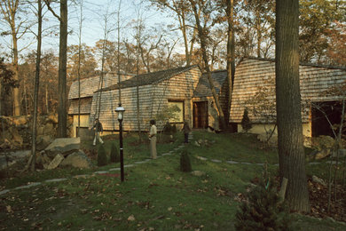 Imagen de fachada gris ecléctica extra grande a niveles con revestimiento de madera y tejado a dos aguas