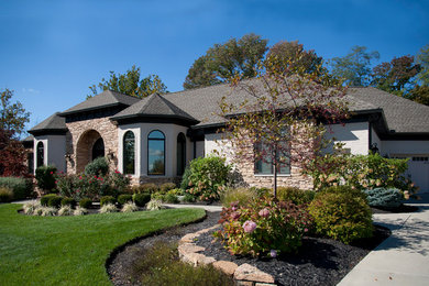 Medium sized and beige mediterranean bungalow house exterior in Cincinnati with mixed cladding.