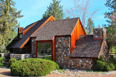 Example of a mid-sized mountain style one-story stone exterior home design in Other