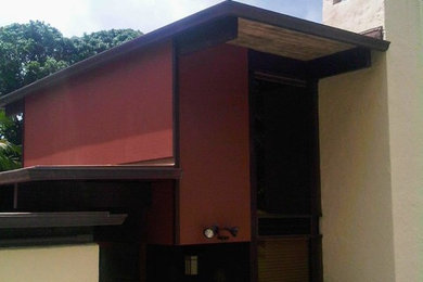 Aménagement d'une grande façade de maison beige asiatique en stuc à un étage avec un toit plat et un toit en métal.