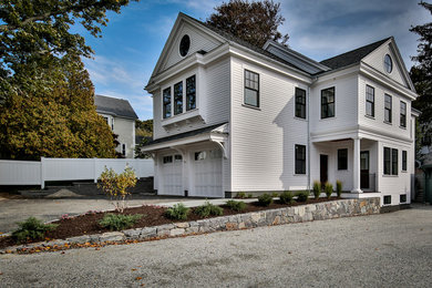 Aménagement d'une façade de maison blanche classique en panneau de béton fibré de taille moyenne et à un étage avec un toit à deux pans.