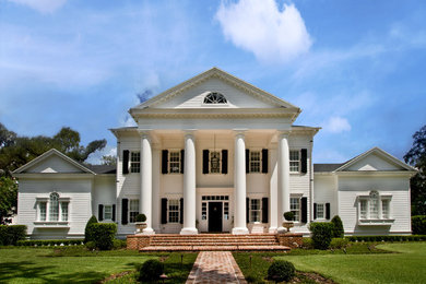 Imagen de fachada de casa blanca clásica extra grande de tres plantas con revestimiento de madera