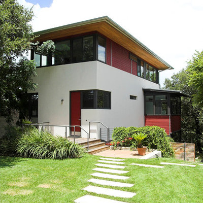 Large trendy beige two-story stucco exterior home photo in Austin