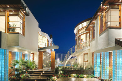 Diseño de fachada de casa blanca actual grande de dos plantas con revestimiento de estuco