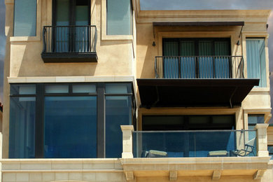 Mid-sized mediterranean beige three-story stone exterior home idea in Orange County