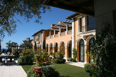 Inspiration for a huge mediterranean two-story stucco house exterior remodel in Los Angeles with a hip roof and a tile roof