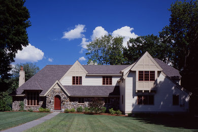 Medium sized and beige traditional two floor house exterior in Boston with wood cladding.