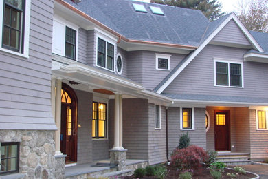 Imagen de fachada gris clásica de tres plantas con revestimientos combinados