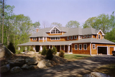 Exemple d'une grande façade de maison marron éclectique en bois à un étage.