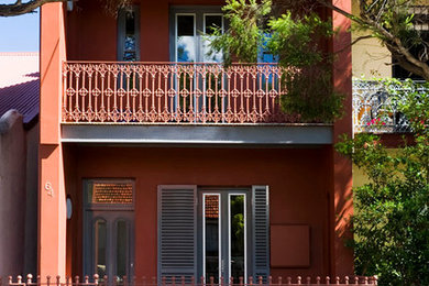 Пример оригинального дизайна: двухэтажный, красный дом среднего размера в классическом стиле с облицовкой из цементной штукатурки и вальмовой крышей