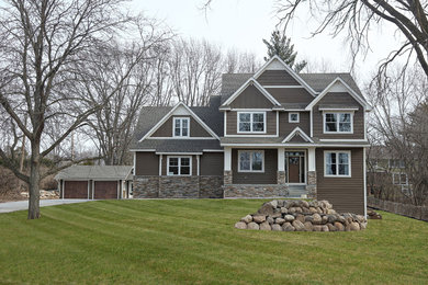 Inspiration for a large timeless brown two-story mixed siding exterior home remodel in Minneapolis with a shingle roof