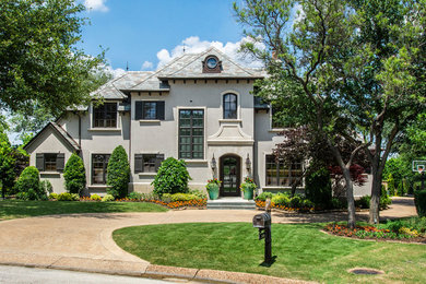 Example of a large classic gray three-story stucco house exterior design in Dallas with a hip roof