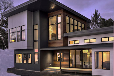 Modelo de fachada de casa gris moderna grande de dos plantas con revestimientos combinados y tejado plano