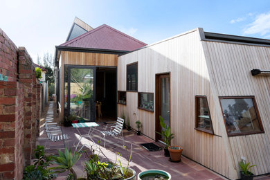 Medium sized contemporary two floor house exterior in Melbourne with wood cladding and a flat roof.