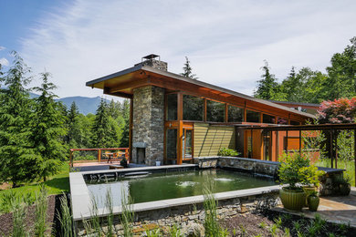 Ejemplo de fachada verde moderna de tamaño medio de dos plantas con revestimientos combinados y tejado de un solo tendido