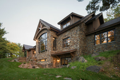 Huge mountain style brown three-story mixed siding exterior home photo in Minneapolis with a mixed material roof