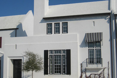 Idee per la facciata di una casa bianca mediterranea a due piani con rivestimento in stucco