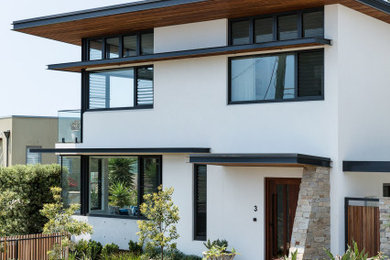 Design ideas for a beach style house exterior in Sydney with three floors.