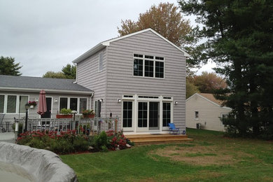 Inspiration for a mid-sized timeless gray one-story vinyl exterior home remodel in New York with a gambrel roof