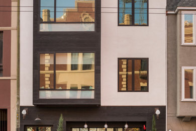 Ejemplo de fachada de piso multicolor contemporánea grande de tres plantas con tejado plano y revestimiento de adobe