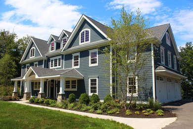 Ejemplo de fachada gris de estilo de casa de campo grande a niveles con revestimiento de madera