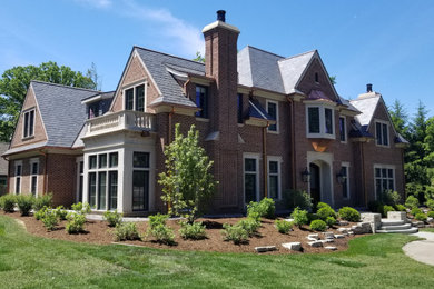 Example of a large classic brown two-story brick house exterior design in Chicago