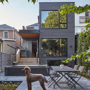 Idee per la facciata di una casa nera scandinava a tre piani con tetto piano