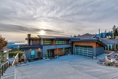 Diseño de fachada de casa gris contemporánea grande de dos plantas con revestimientos combinados, tejado plano y tejado de metal