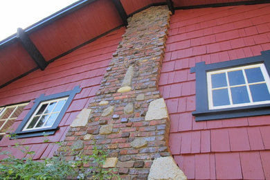 Ejemplo de fachada de casa roja clásica de tamaño medio de dos plantas con revestimiento de madera y tejado a dos aguas