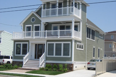 Example of a beach style green three-story vinyl exterior home design in Philadelphia