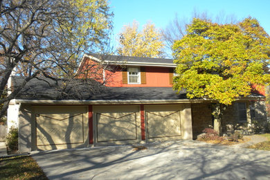 Modelo de fachada roja tradicional grande a niveles con revestimiento de madera y tejado a dos aguas