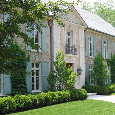 Example of a huge classic beige two-story brick house exterior design in Chicago with a hip roof and a green roof