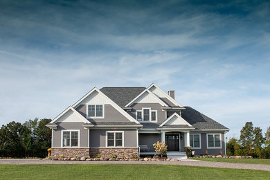 Foto de fachada de casa gris clásica de tamaño medio de dos plantas con revestimiento de vinilo, tejado a cuatro aguas y tejado de teja de madera