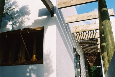 Cette image montre une façade de maison blanche minimaliste en stuc de taille moyenne et de plain-pied.