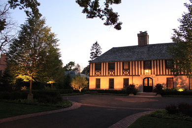 Imagen de fachada de casa beige tradicional grande de dos plantas con tejado a cuatro aguas, revestimiento de estuco y tejado de teja de madera