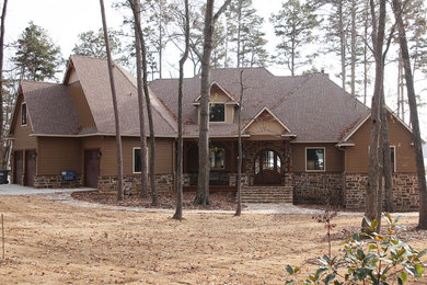 Idée de décoration pour une grande façade de maison marron chalet à un étage avec un revêtement mixte et un toit à quatre pans.