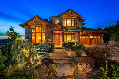 Mountain style green two-story house exterior photo in Seattle with a hip roof and a shingle roof