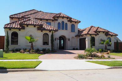 Large and beige mediterranean two floor render house exterior in Dallas with a hip roof.