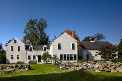 Example of a classic white two-story gable roof design in Boston