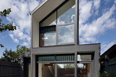Mid-sized contemporary black two-story mixed siding exterior home idea in Melbourne with a shed roof