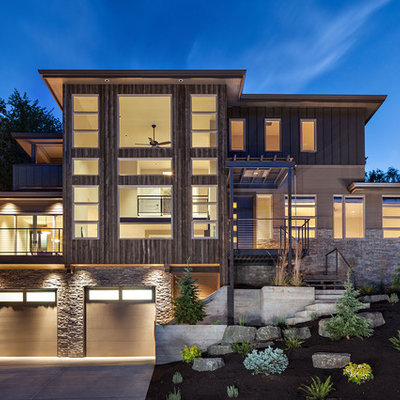 Large contemporary beige three-story wood exterior home idea in Portland with a hip roof
