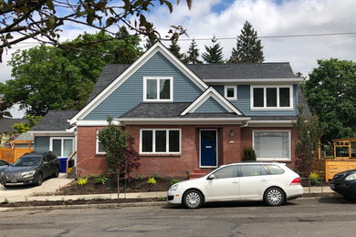 Example of a mid-sized transitional blue three-story wood exterior home design in Portland with a shingle roof