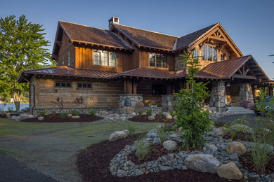 Huge mountain style brown two-story wood exterior home photo in New York with a mixed material roof