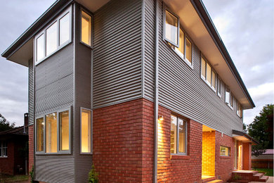 Medium sized and gey contemporary two floor house exterior in Canberra - Queanbeyan with mixed cladding.