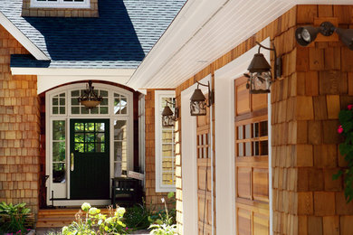 Imagen de fachada marrón de estilo americano de dos plantas con revestimiento de madera y tejado a dos aguas