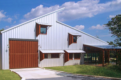 Example of a large urban two-story metal house exterior design in Austin with a shed roof and a metal roof