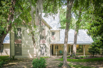 ヒューストンにあるカントリー風のおしゃれな家の外観 (コンクリート繊維板サイディング、黄色い外壁) の写真