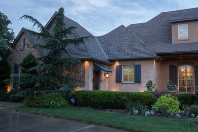 Ejemplo de fachada de casa beige minimalista grande de dos plantas con revestimiento de estuco, tejado a dos aguas y tejado de teja de madera