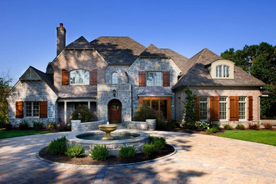 Example of a large arts and crafts gray two-story stone exterior home design in Other with a shingle roof