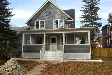 Inspiration for a mid-sized transitional gray two-story wood gable roof remodel in Other